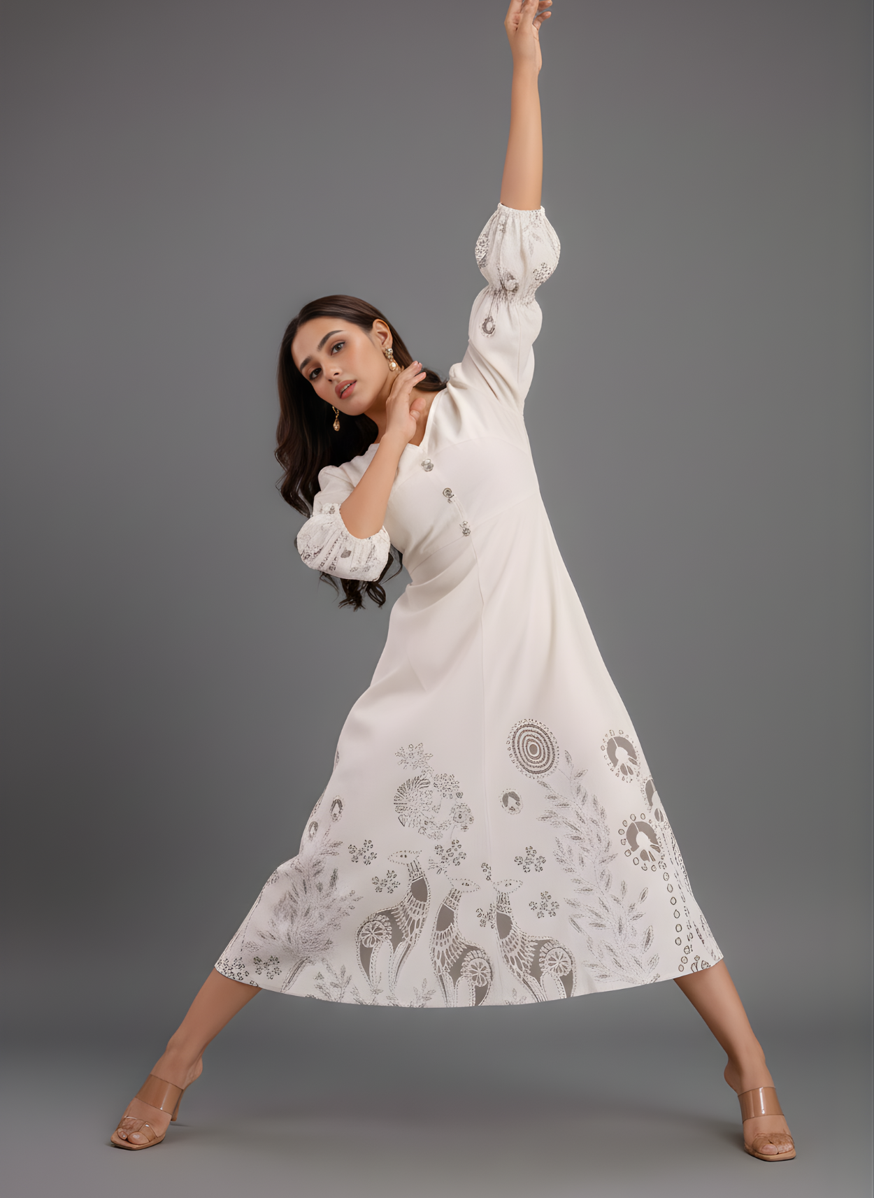 Woman wearing a white dress with patterns on a gray background