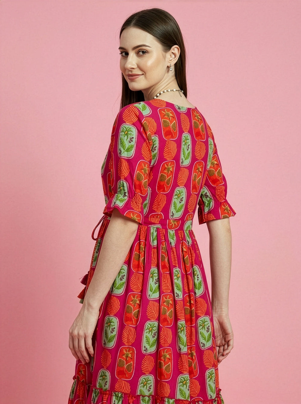 Woman wearing a colorful dress with a pink background