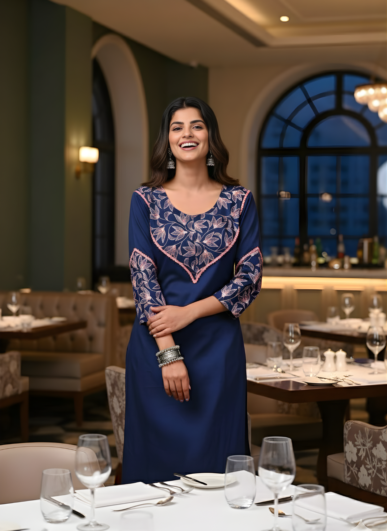Woman in a blue dress standing in a restaurant setting