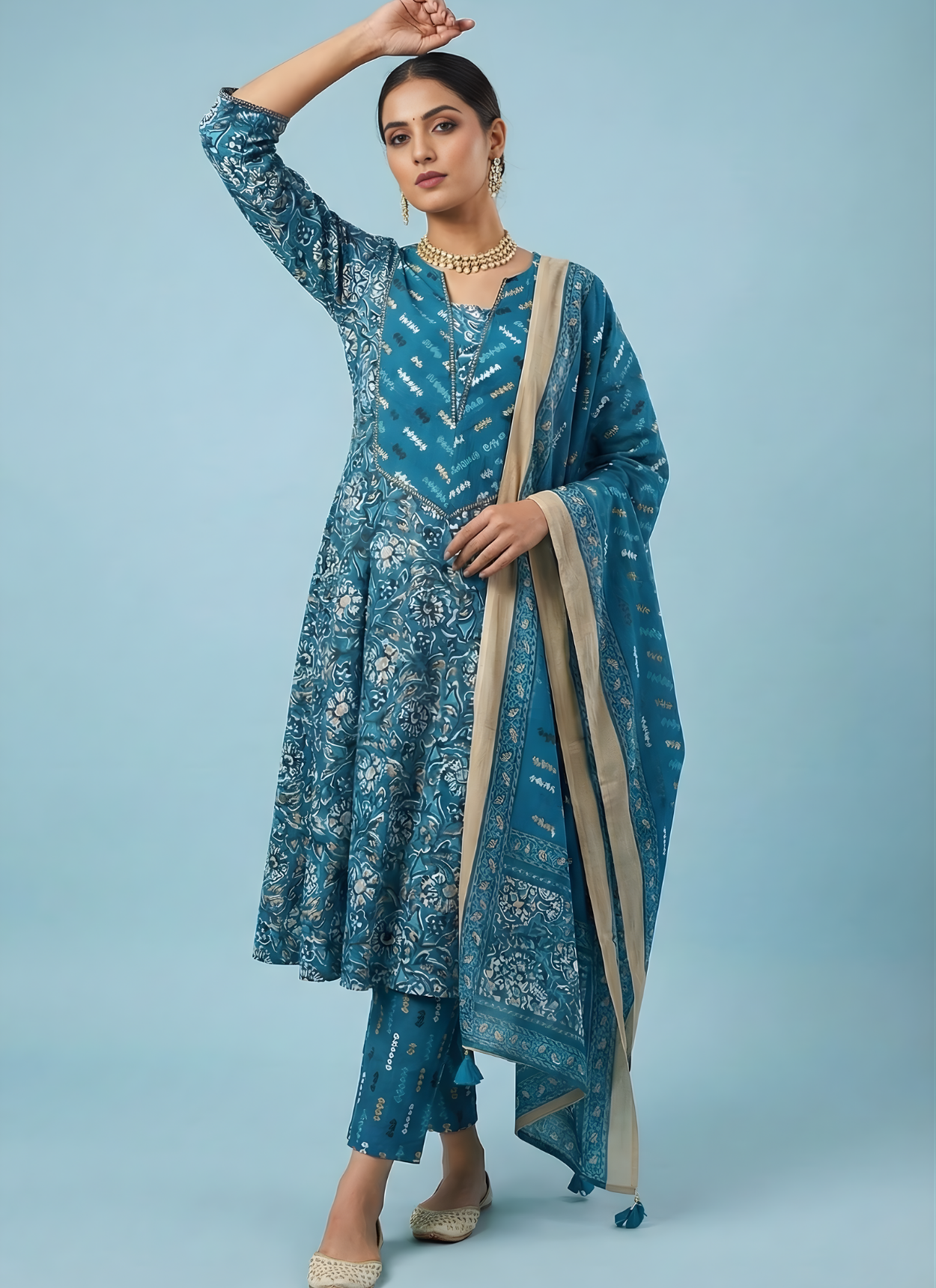 Woman wearing a blue traditional outfit with a matching dupatta on a light blue background