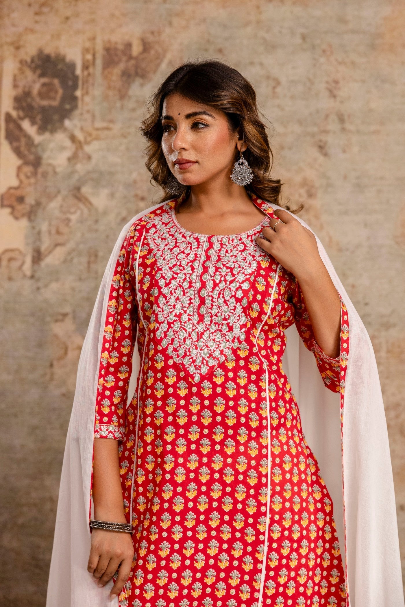 Woman wearing a red and white patterned dress with a plain background