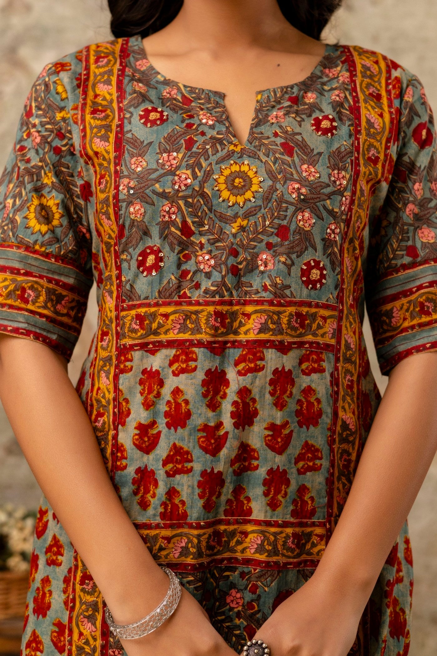 Person wearing a colorful patterned dress with a blurred background