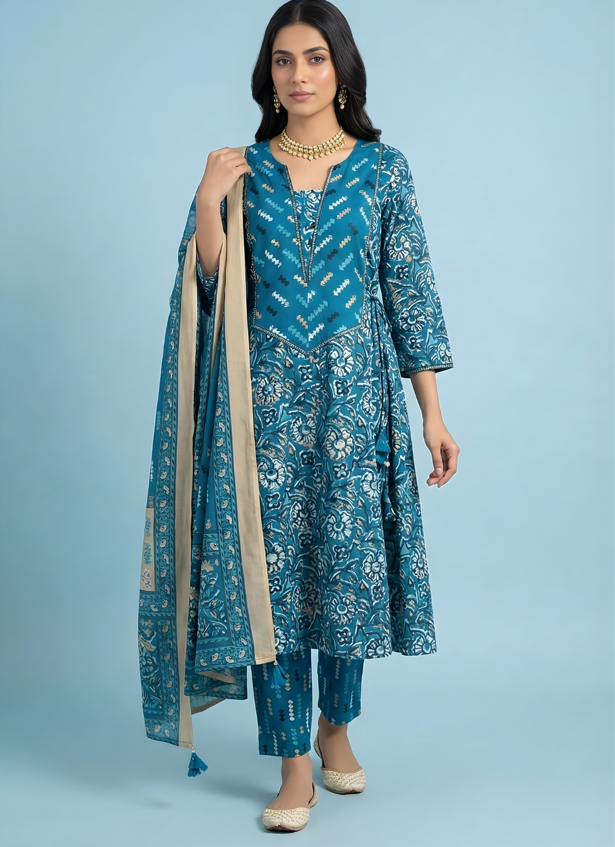 Woman wearing a blue embroidered traditional outfit with a plain background