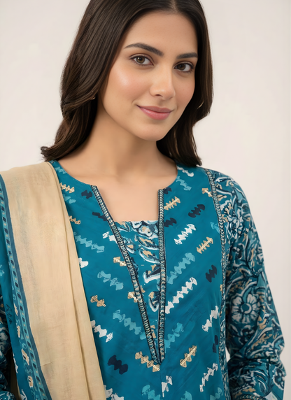 Woman wearing a blue patterned outfit with a beige scarf against a white background