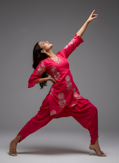 Dancer in a bright pink traditional outfit with white patterns on a gray background