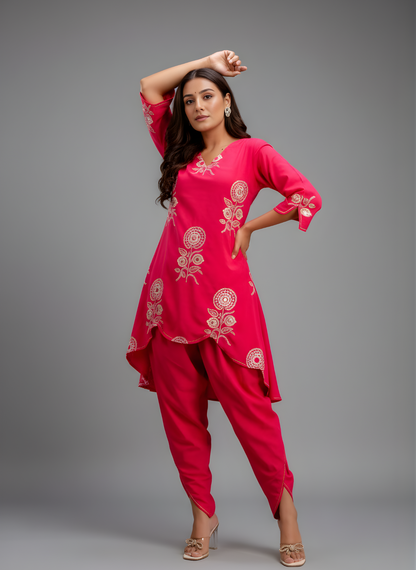 Woman wearing a pink traditional outfit with floral embroidery on a gray background